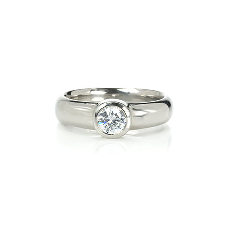 Crafted in 14KT white gold, this ring features a bezel set round brilliant-cut diamond. 