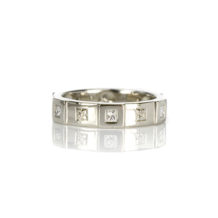 Crafted in 14KT white gold, this ring features six raised sections, each set with a princess-cut diamond. Alternating with hand-engraved orange blossoms in square settings. 