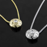 A 14KT white gold and a 14KT yellow gold ‘Opulence Paisley Hand-engraved Diamond Pendant’ are shown side by side. 