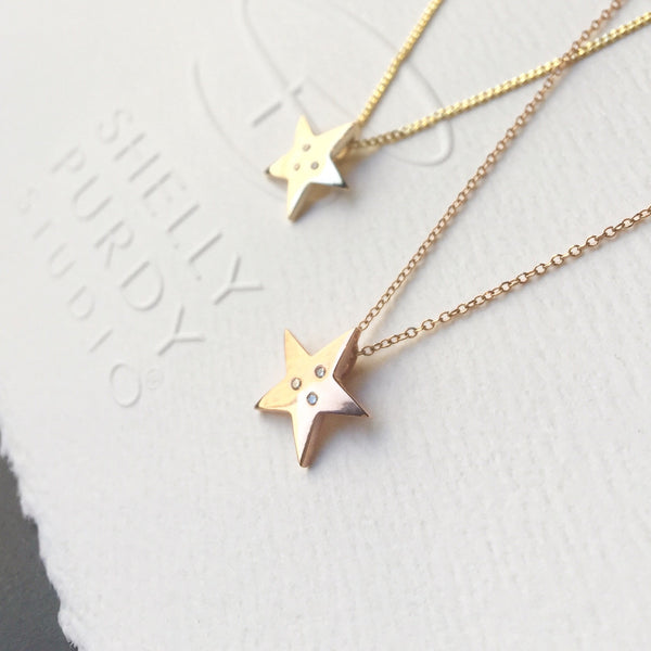 Crafted in 14KT yellow gold, this star shaped pendant is set with 3 round brilliant-cut diamonds. 