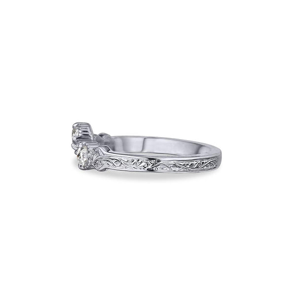 Crafted in 14KT white gold, this ring has a curve featuring 3 rose-cut diamonds in a row on a vintage-inspired hand engraved band.