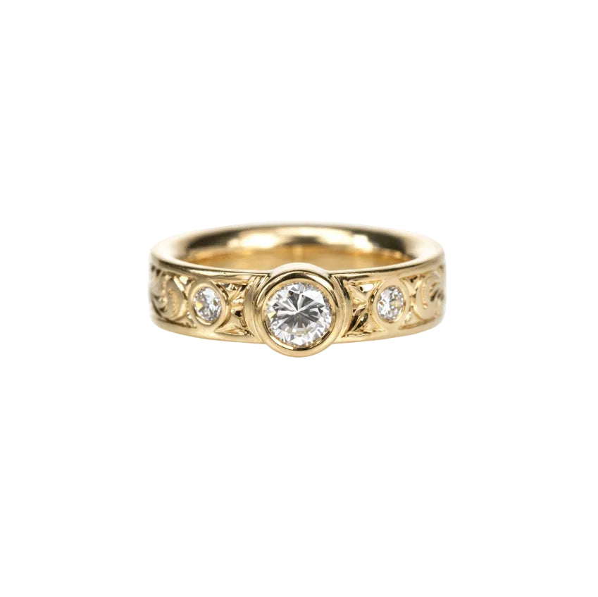 Crafted in 14KT gold, this comfort-fit engagement ring is set with a round brilliant-cut diamond between two smaller round brilliant-cut diamonds on a paisley hand-engraved band. 