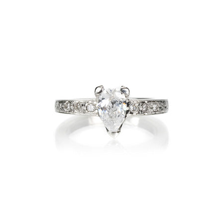 Crafted in 14KT white gold, this ring features a pear-shape diamond in a three prong setting on an orange blossom hand-engraved band set with round-cut  diamonds.