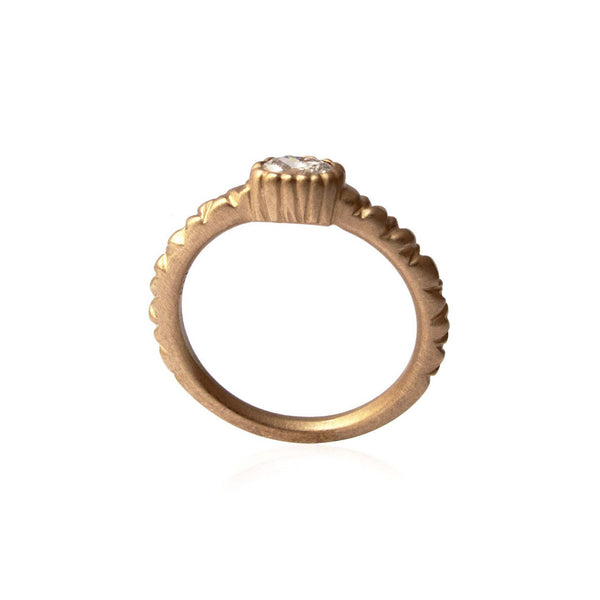 Crafted in 14KT brushed yellow gold, this ring features a bezel-set oval-cut diamond on a quilted band. 