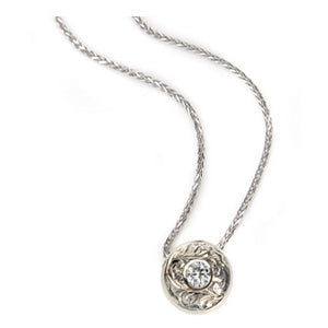 Crafted in 14KT white gold, this slider pendant features a round brilliant-cut diamond with a paisley hand-engraved halo. 