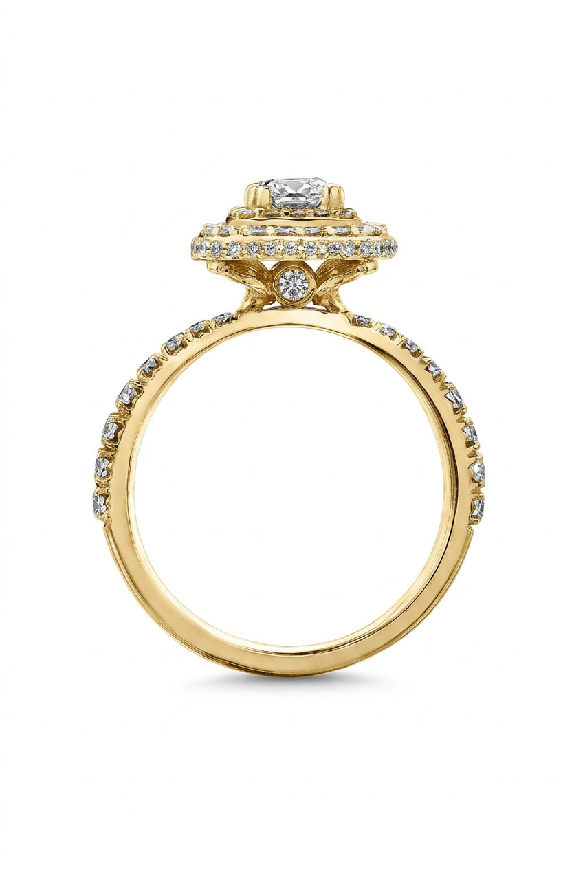 Crafted in 18KT Certified Canadian Gold, this ring features a diamond set double halo with a cushion-cut Canadian centre diamond. Diamond set band and has hidden maple leaf details.